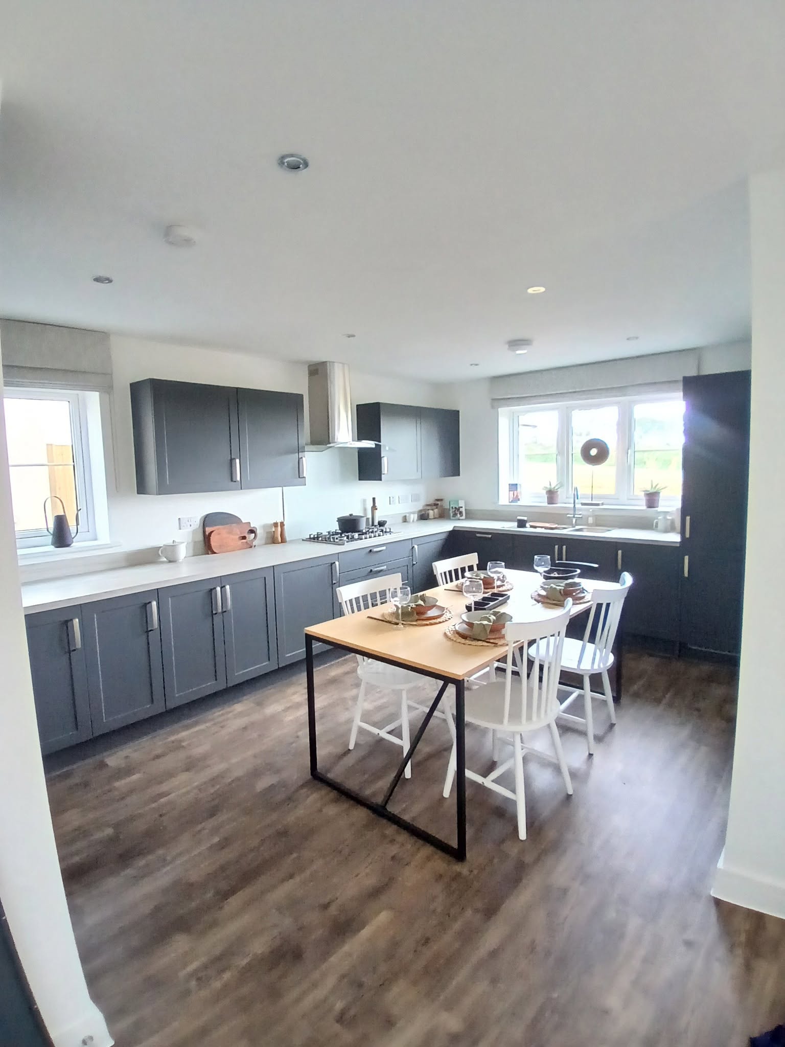 Dark grey shaker-style kitchen in an open-plan room with an oak dining table