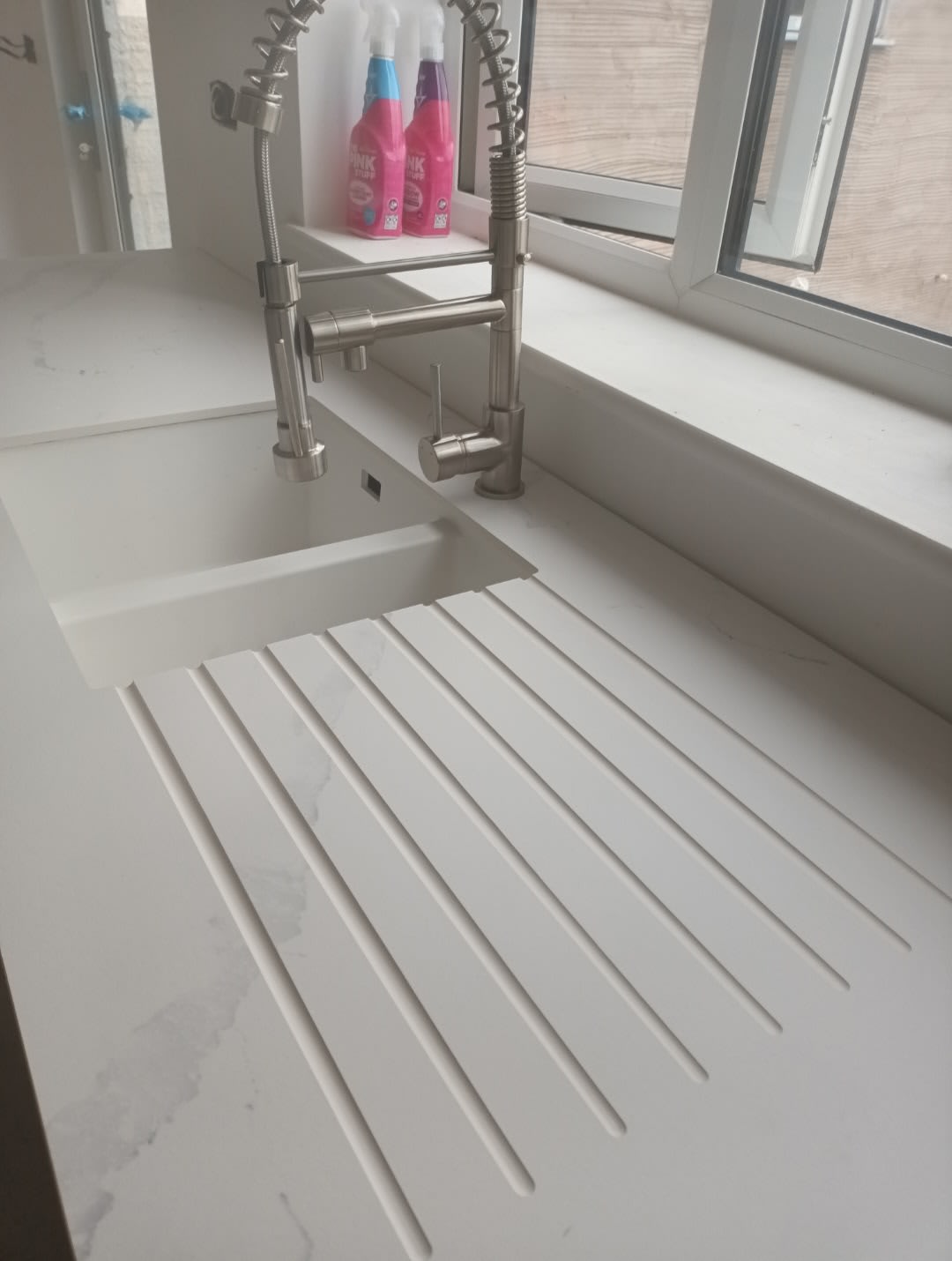 White integrated sink with a grooved drainer