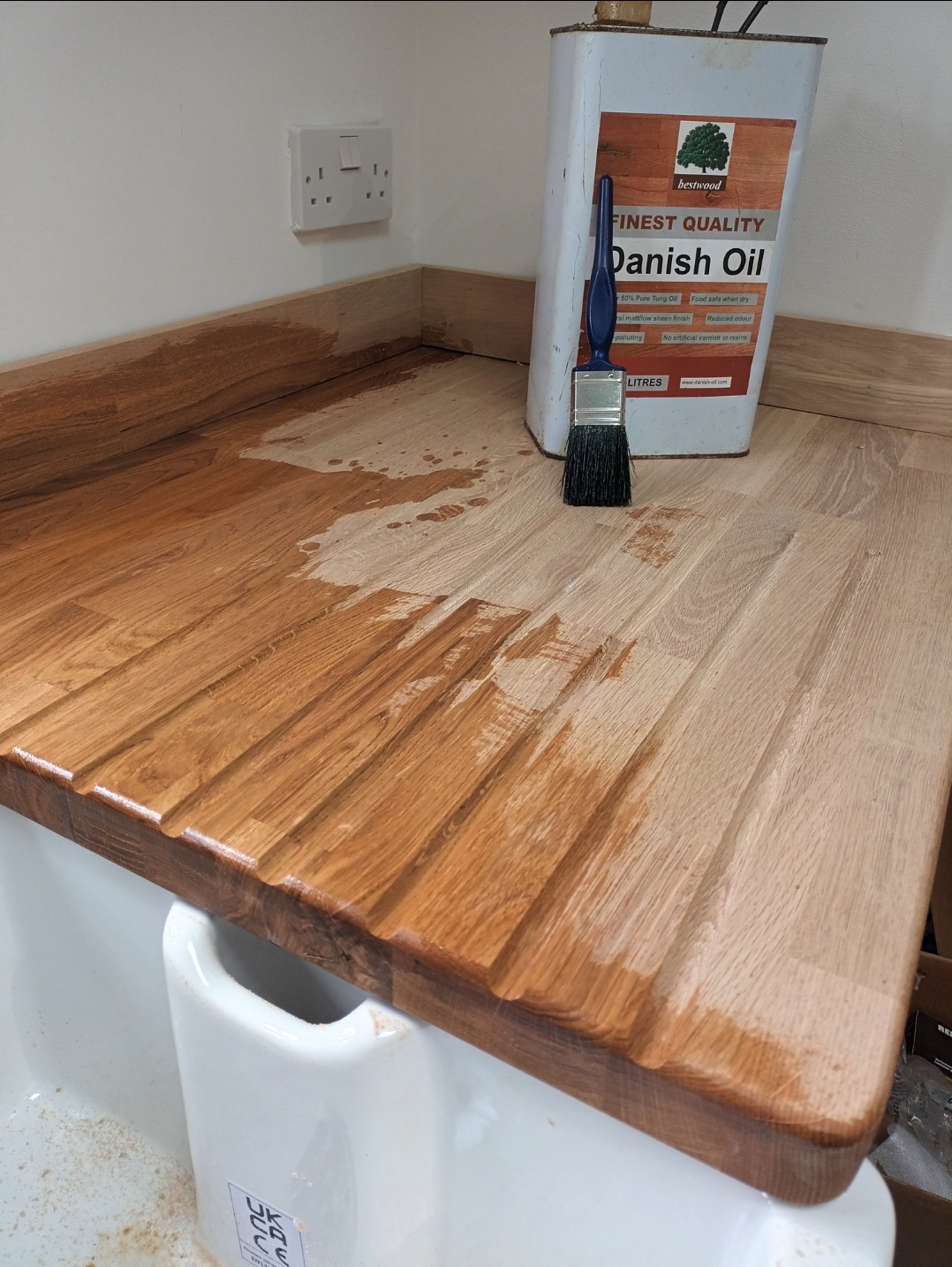 A solid oak worktop with a grooved drainer being oiled